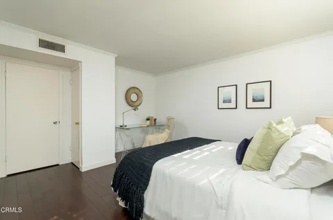 a bedroom with a bed and a painting on the wall