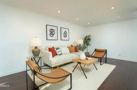 a living room with furniture and a painting on the wall