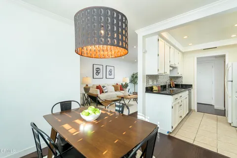a kitchen with stainless steel appliances a table and chairs