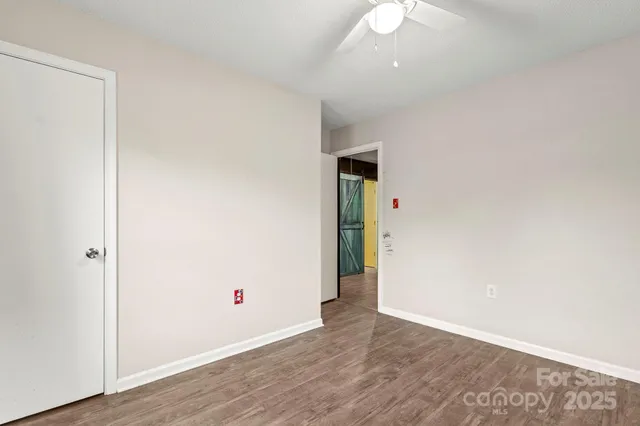 a view of an empty room with wooden floor