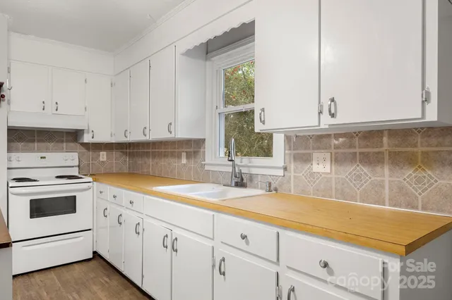a kitchen with granite countertop white cabinets and white appliances