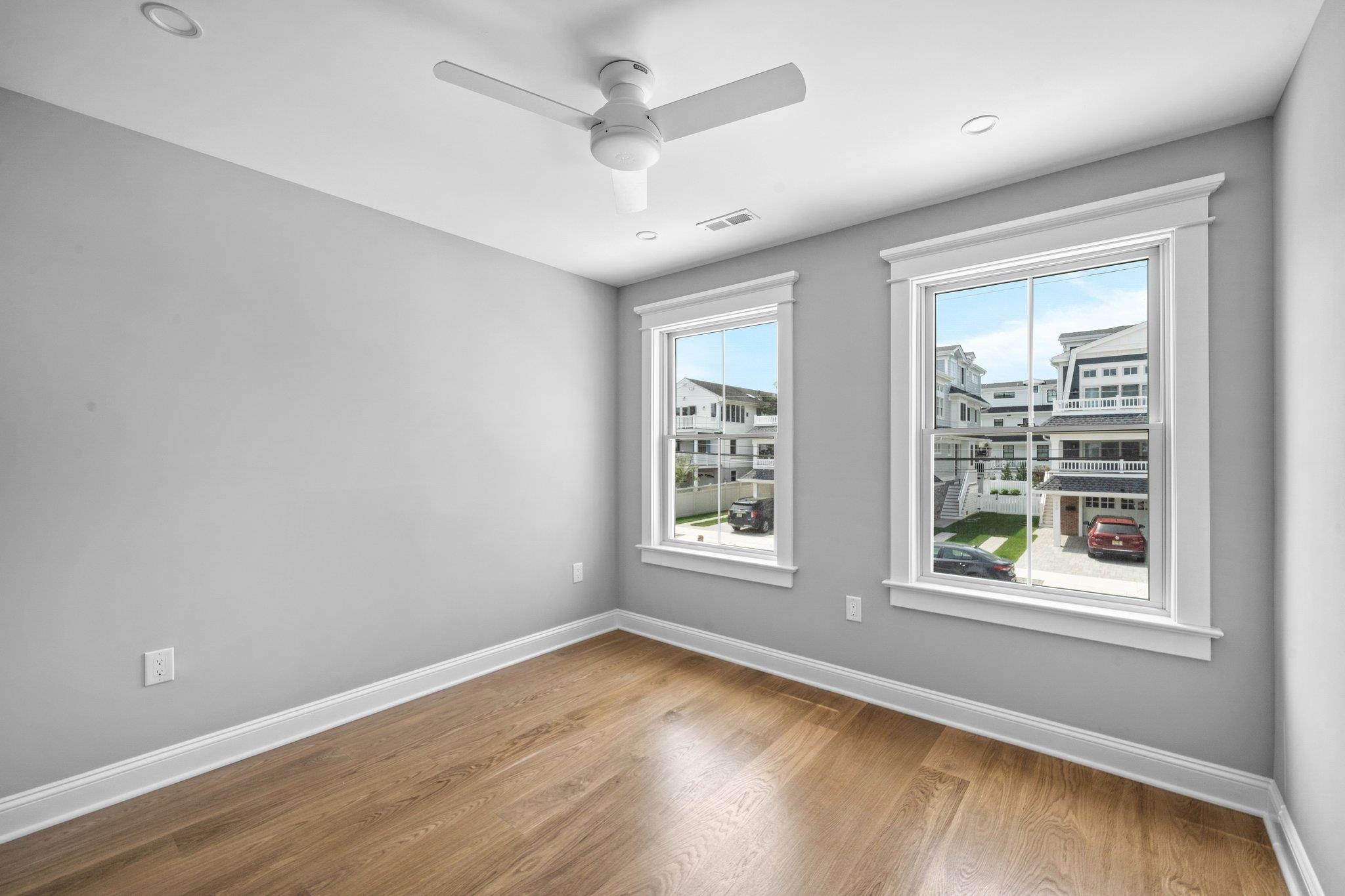 297 24th, Unit 297 Avalon, NJ 08202 - Photo 14 of 49 an empty room with wooden floor and windows