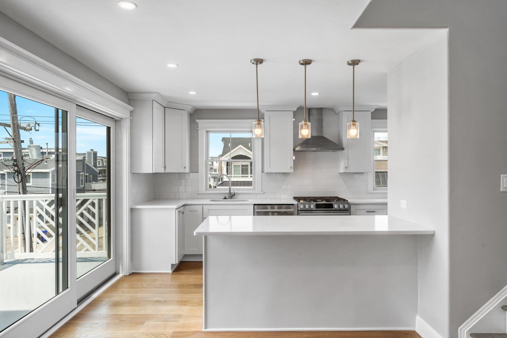 297 24th, Unit 297 Avalon, NJ 08202 - Photo 31 of 49 a kitchen with stainless steel appliances granite countertop a sink a stove a refrigerator and white cabinets with wooden floor