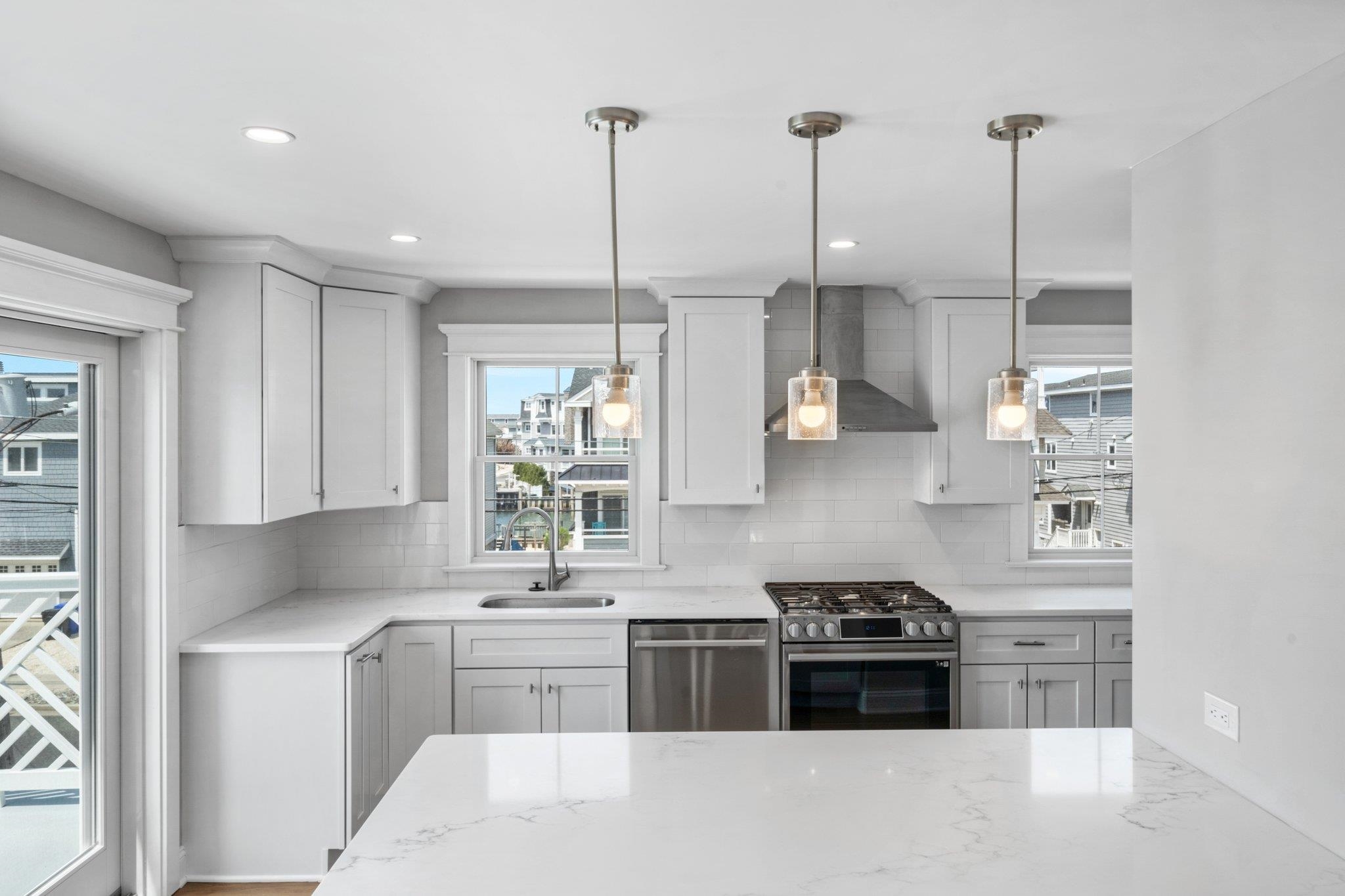 297 24th, Unit 297 Avalon, NJ 08202 - Photo 37 of 49 a kitchen with stainless steel appliances granite countertop a stove a sink and a refrigerator