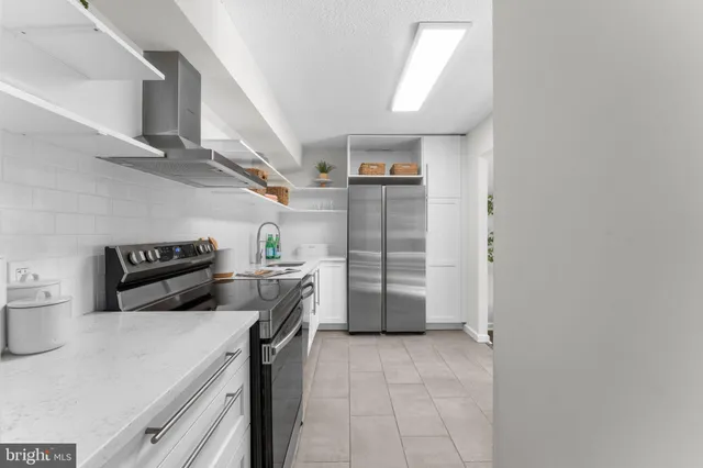 a kitchen with stainless steel appliances granite countertop a sink and dishwasher a stove top oven with white cabinets