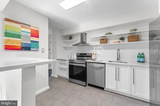 a kitchen with stainless steel appliances granite countertop a refrigerator and a stove
