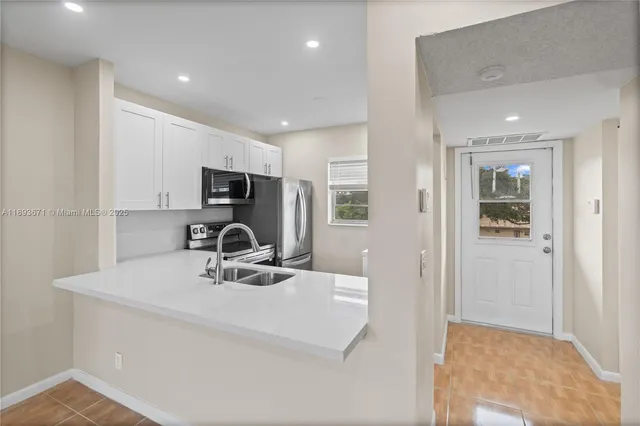 a kitchen with kitchen island a sink appliances and cabinets