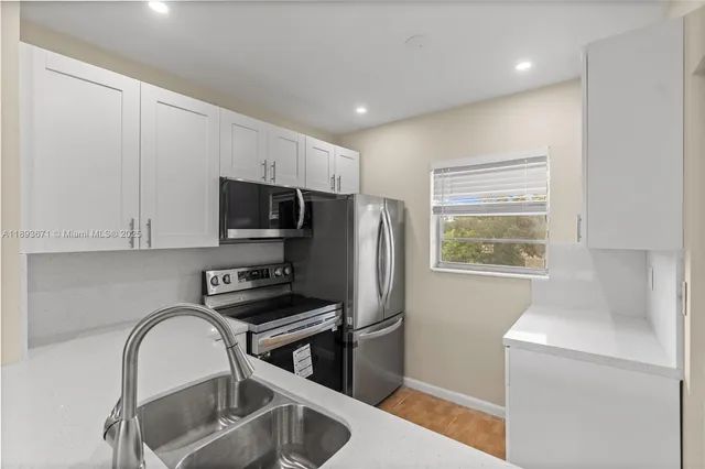 a kitchen with a refrigerator sink and stove