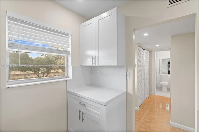 a view of kitchen with granite countertop cabinets and window