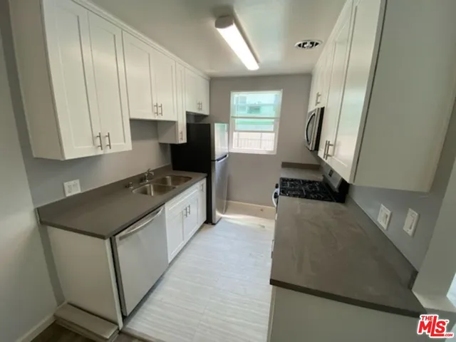 a kitchen with a refrigerator and a stove top oven