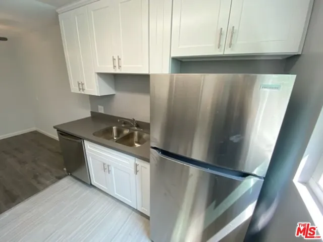 a kitchen with granite countertop a sink stove and refrigerator