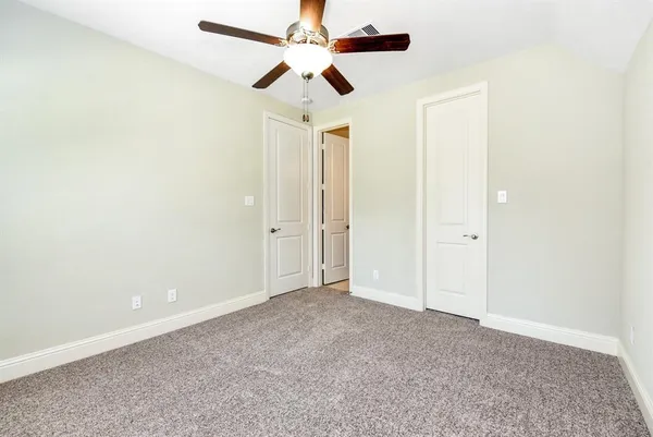an empty room with a ceiling fan and a window