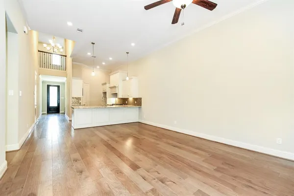 a view of a kitchen with wooden floor a sink a refrigerator and window