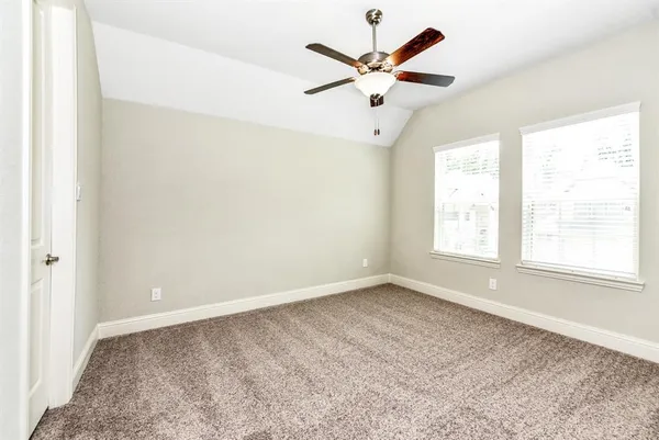 an empty room with a window and a fan