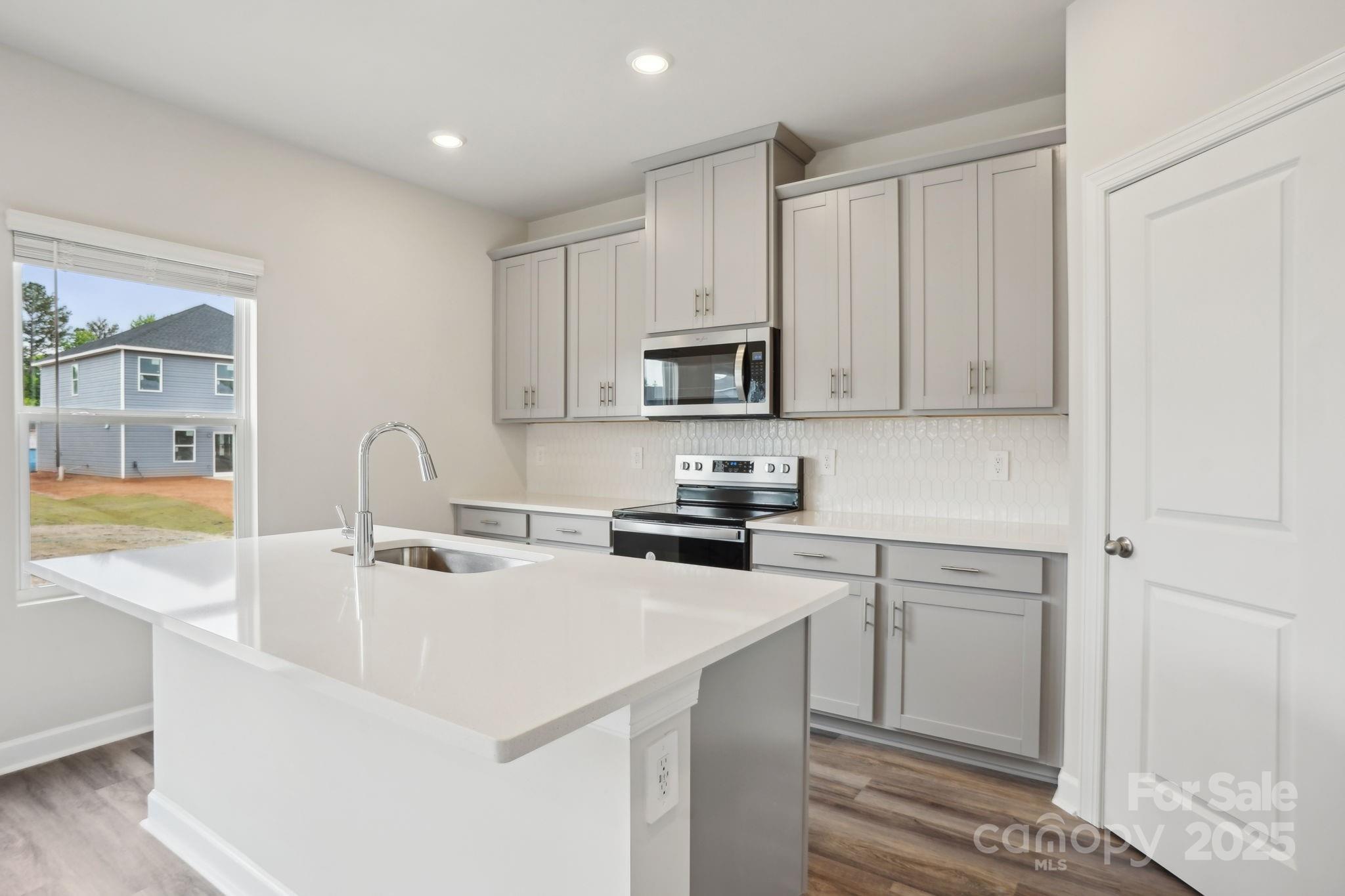 196 Murphy Mdw Road Mocksville, NC 27028 - Photo 10 of 24 a kitchen with stainless steel appliances granite countertop a sink a stove and a refrigerator with wooden floors