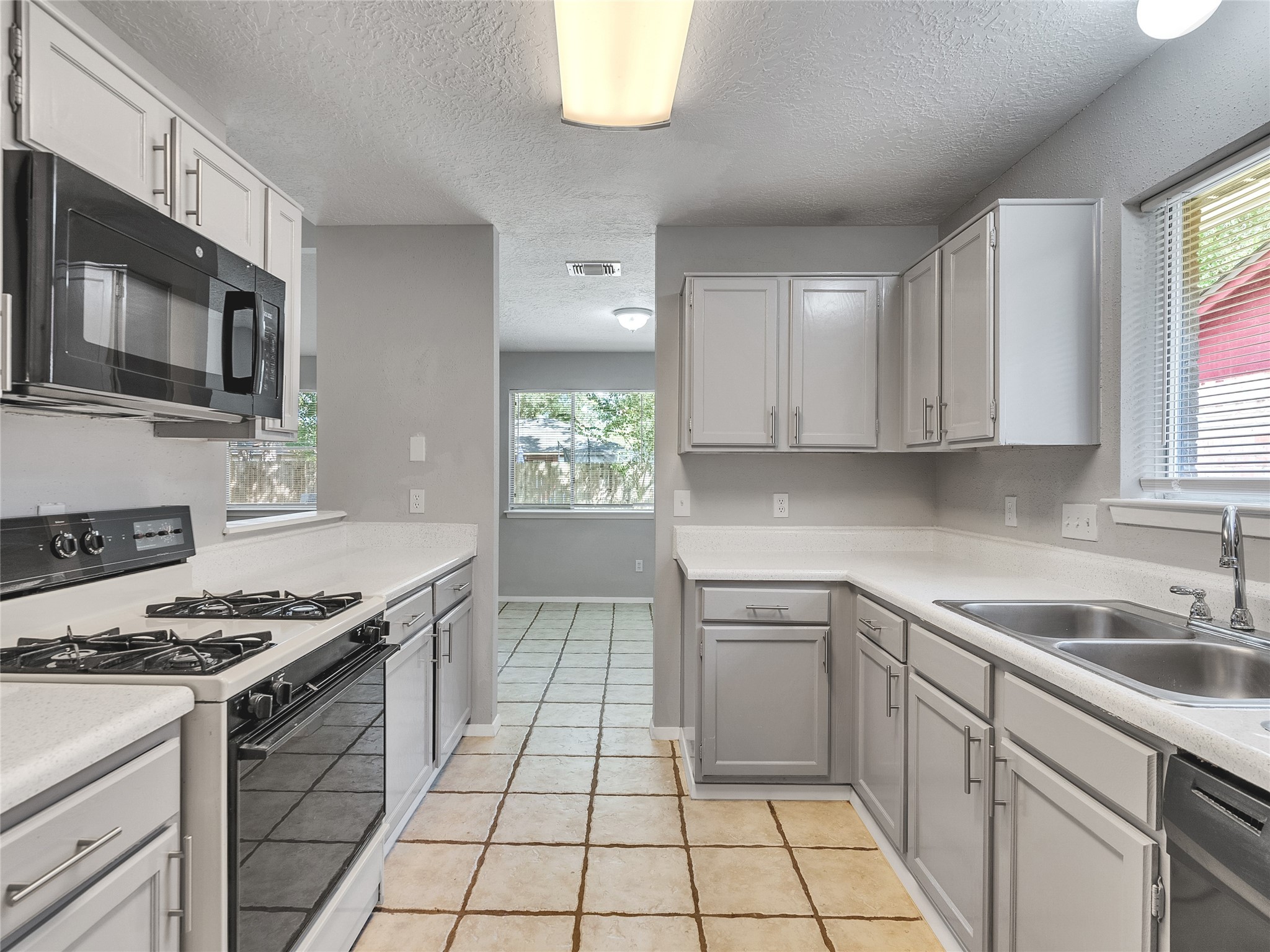 24006 Spring Gum Drive Spring, TX 77373 - Photo 12 of 31 a kitchen with stainless steel appliances granite countertop a sink a stove a microwave and cabinets