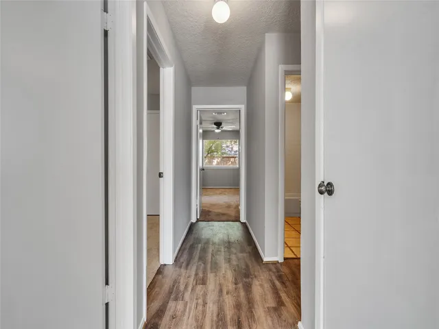 a view of a hallway with wooden floor