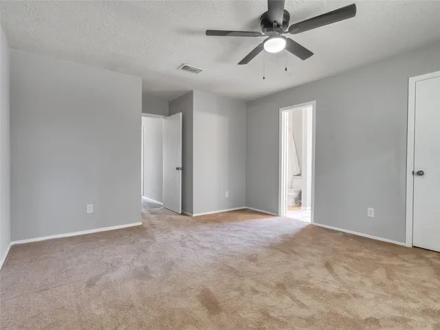 an empty room with closet and a chandelier fan