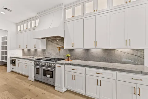 a kitchen with white cabinets and white stainless steel appliances