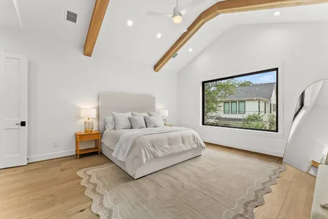 a spacious bedroom with a large bed and a large window