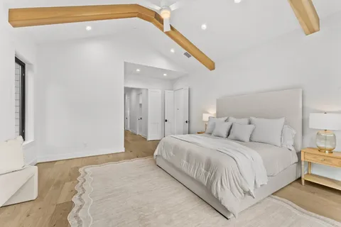 a bedroom with a large bed and a chandelier