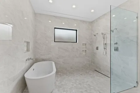a bathroom with a white bath tub and shower