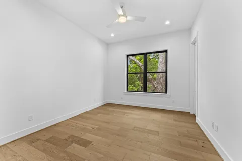 an empty room with a window and a ceiling fan