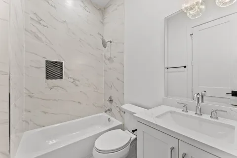 a bathroom with a toilet a sink a mirror and bathtub