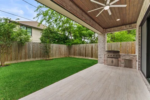 a view of a backyard with table and chairs and a barbeque