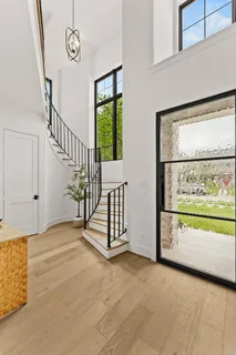 a view of a hallway with wooden floor and a window