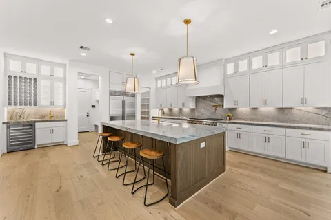 a kitchen with stainless steel appliances granite countertop a stove and white cabinets