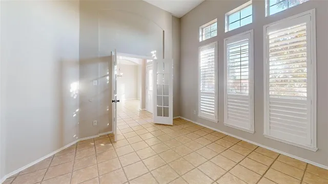 an empty room with windows and fireplace