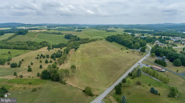 an aerial view of a residential houses with outdoor space and trees
