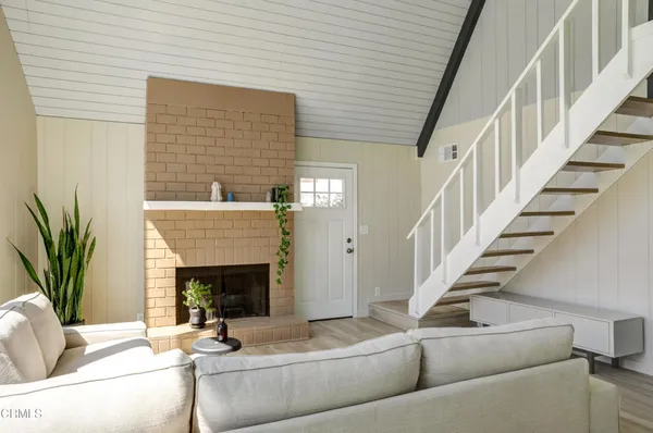 a living room with fireplace furniture and a potted plant