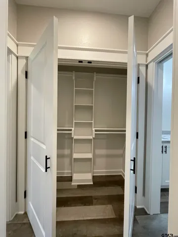 a view of walk in closet with empty racks