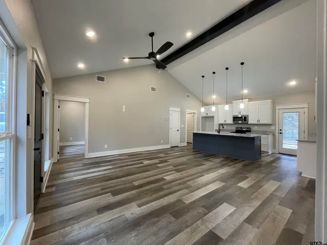 a view of an empty room and kitchen view