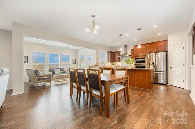 a living room with stainless steel appliances kitchen island granite countertop furniture and wooden floor