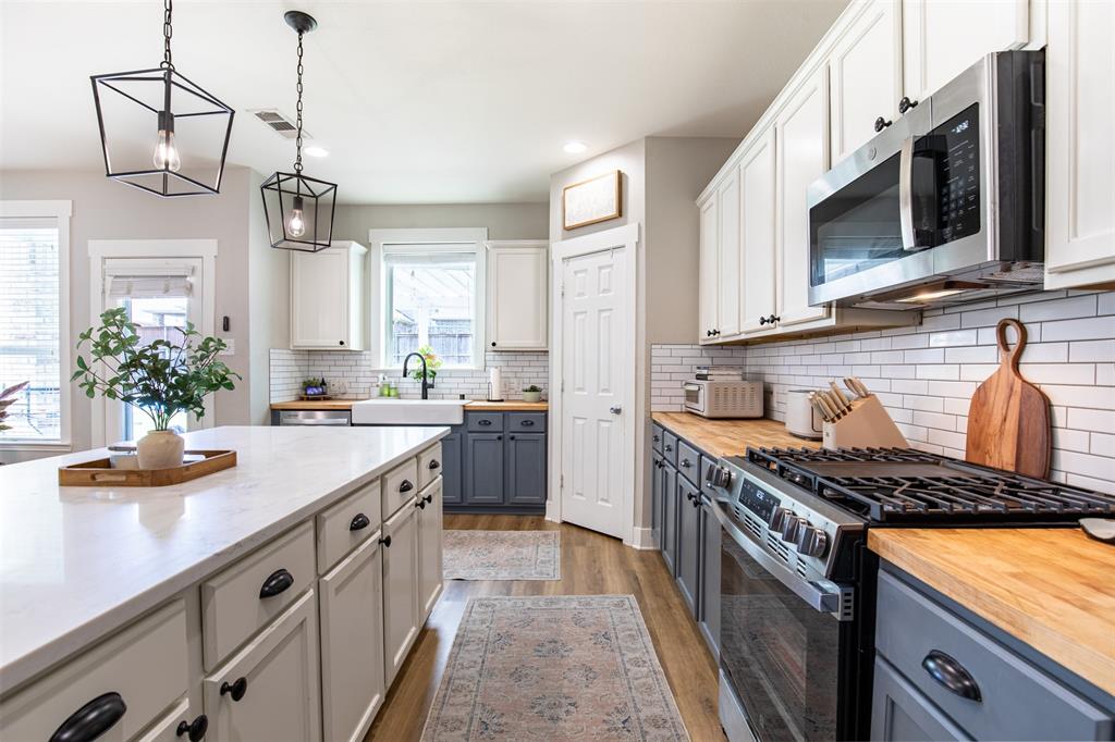 416 Allbright Road Celina, TX 75009 - Photo 12 of 40 a kitchen with stainless steel appliances granite countertop a stove a sink dishwasher and microwave with wooden floor