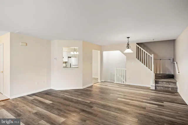 a view of a hallway with wooden floor and staircase