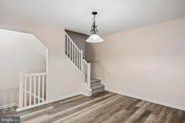 a view of a hallway with wooden floor and stairs
