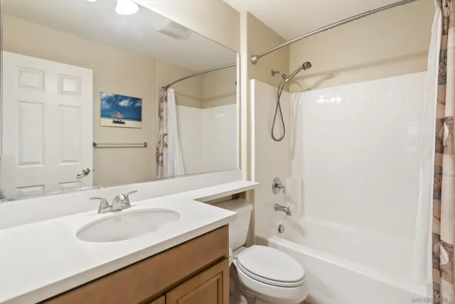 a bathroom with a granite countertop sink toilet tub and shower