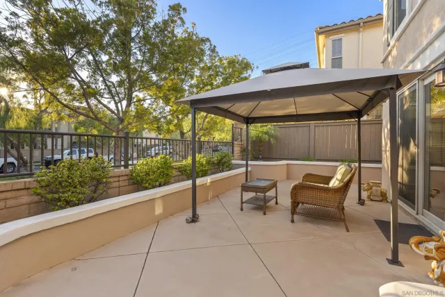 a view of a patio with a table and chairs under an umbrella