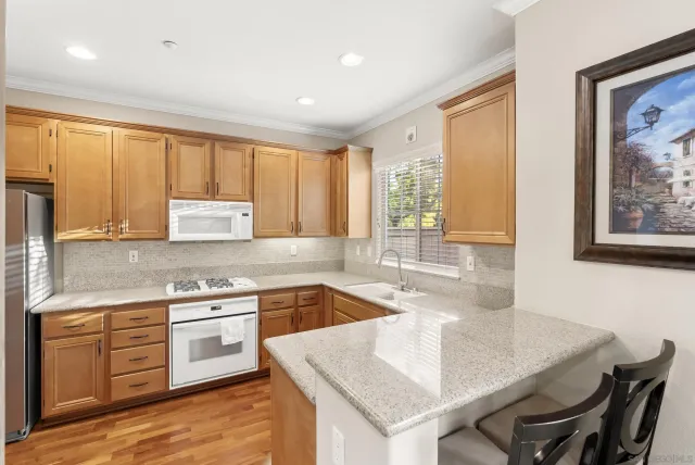 a kitchen with a stove a sink a table and chairs