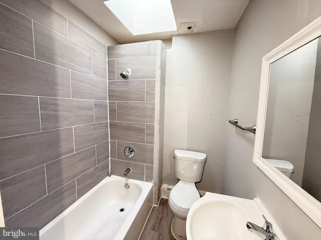 a white toilet sitting next to a bath tub