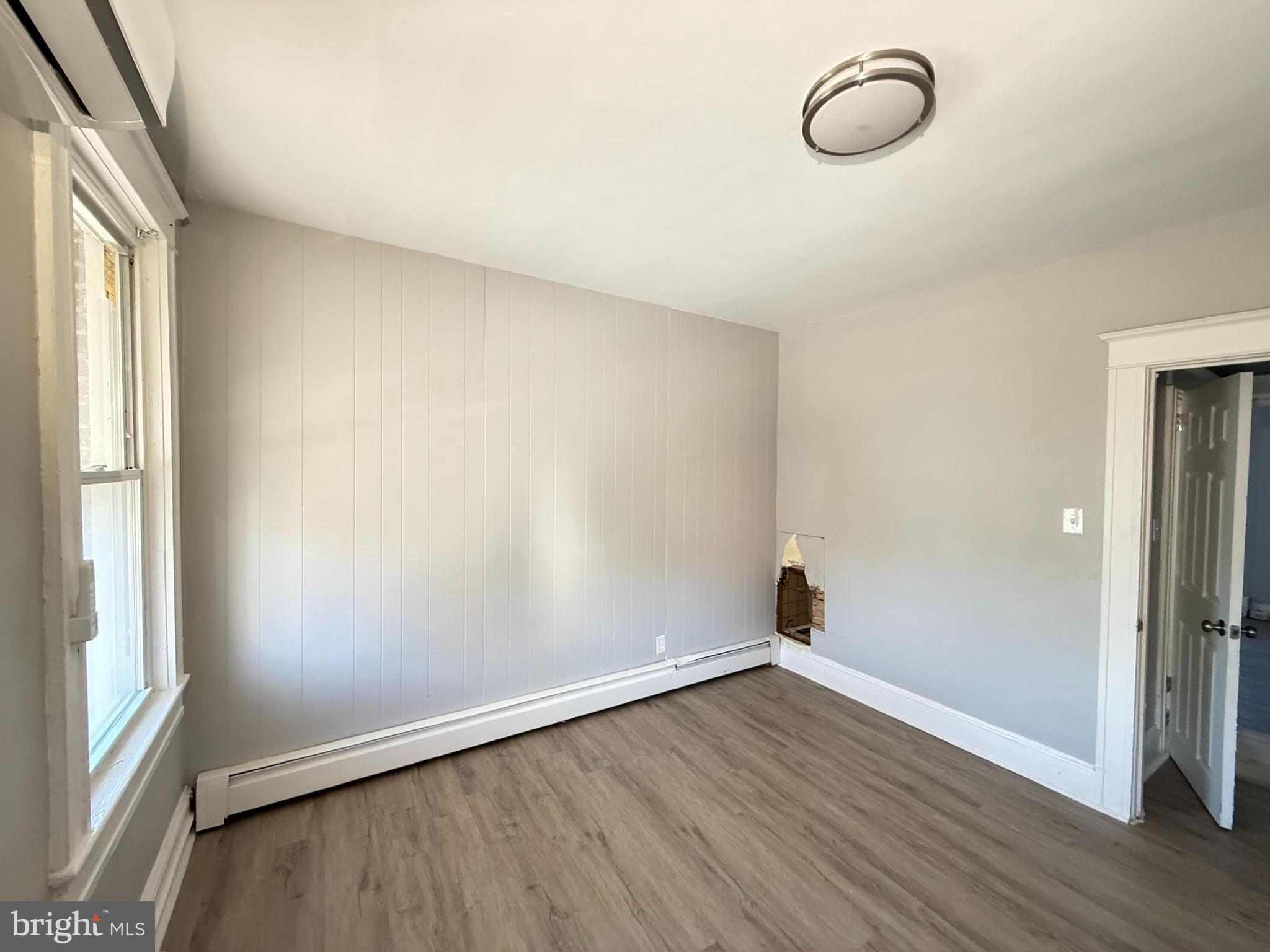 2662 Lehman Street Baltimore, MD 21223 - Photo 9 of 10 an empty room with wooden floor and windows