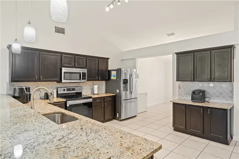 a kitchen with stainless steel appliances granite countertop a sink stove and refrigerator
