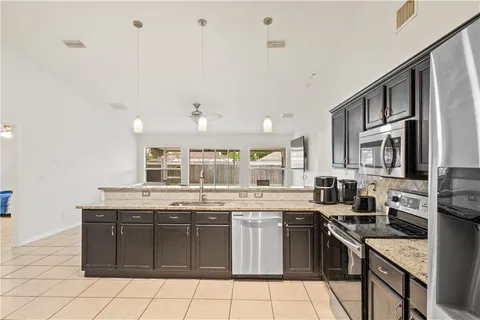 a kitchen with stainless steel appliances granite countertop a stove sink and cabinets