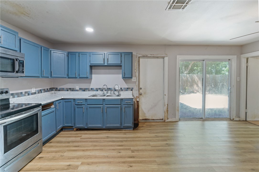 1806 Melisa Lane Corpus Christi, TX 78412 - Photo 2 of 13 a kitchen with granite countertop wooden floors and wide window