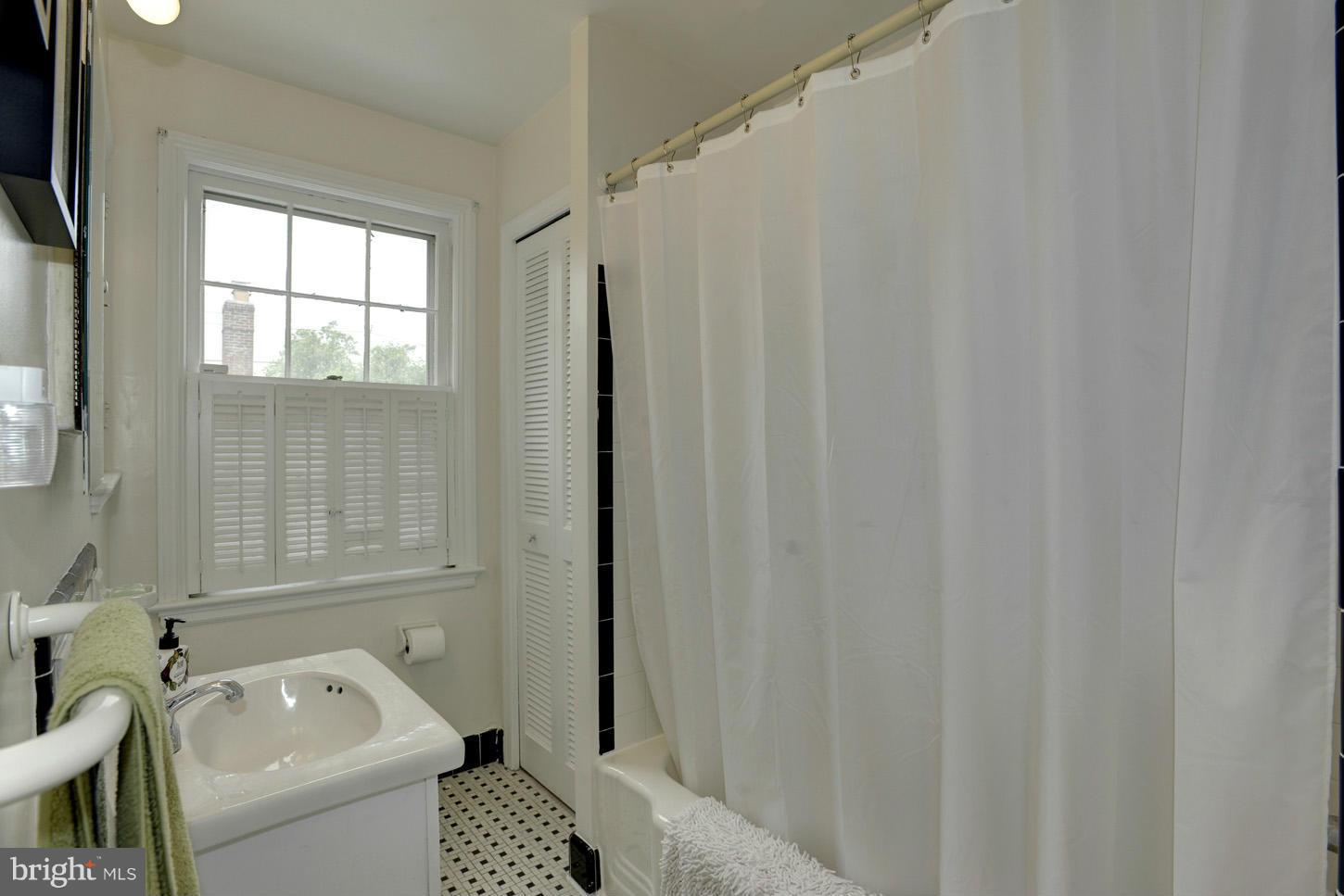 4625 Sedgwick Street Northwest Washington, DC 20016 - Photo 14 of 19 a bathroom with a sink a toilet and shower curtain