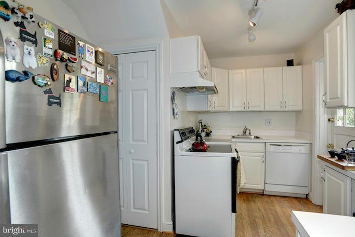 4625 Sedgwick Street Northwest Washington, DC 20016 - Photo 9 of 19 a kitchen with stainless steel appliances a refrigerator a sink cabinets and wooden floor